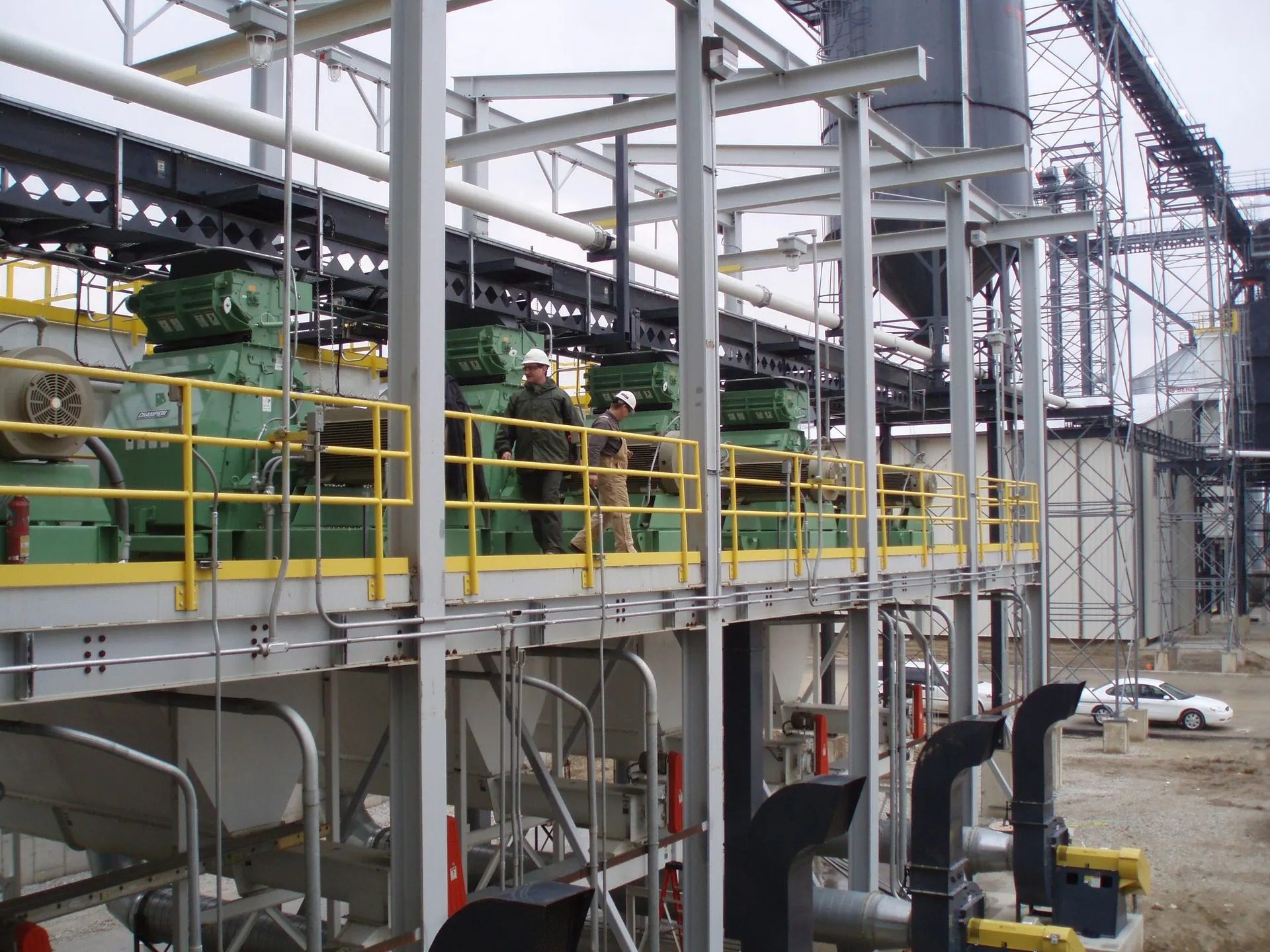 Industrial machinery with workers on a platform.